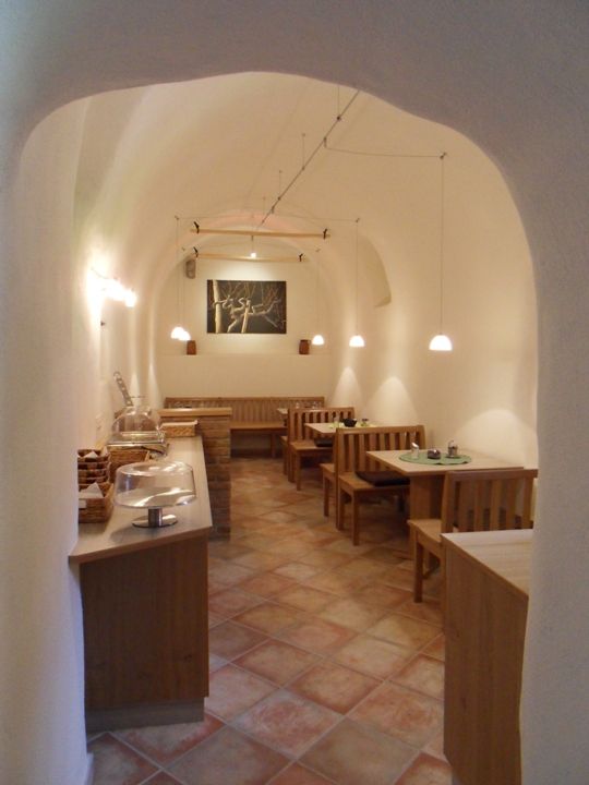 A cozy breakfast room with wooden furniture and a vaulted ceiling.