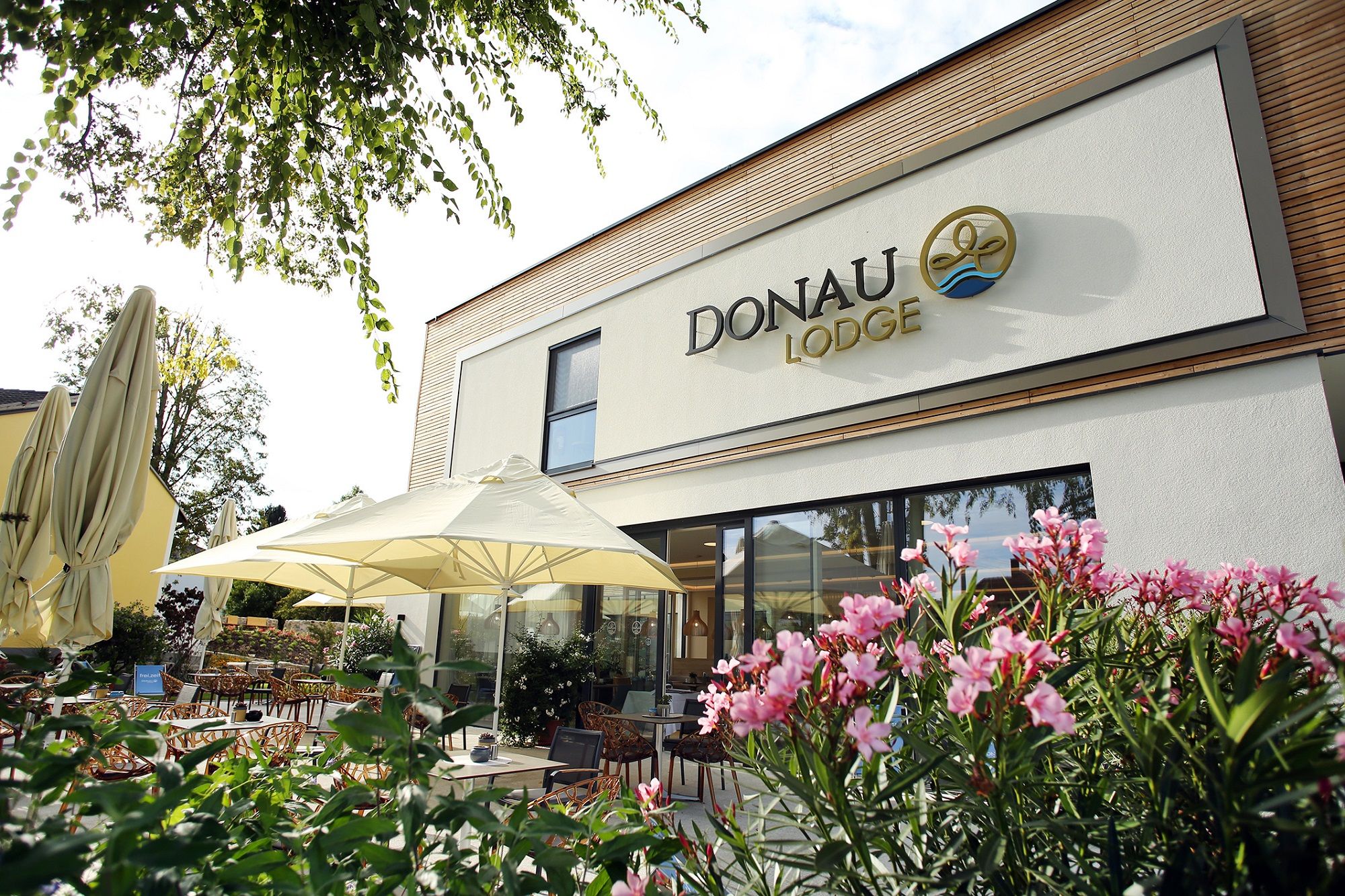Exterior view of the Donau Lodge Ybbs with terrace and parasols.