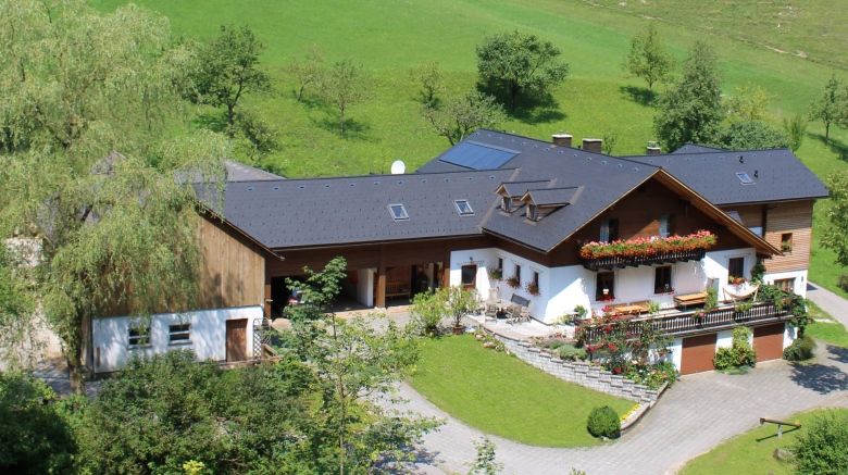 Aerial view of a farm with a green roof and floral decorations.