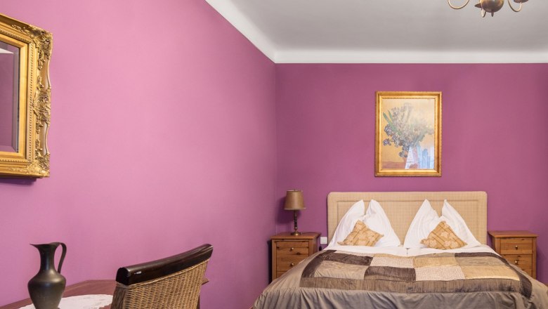 A cozy guest room with double bed and chandelier