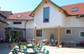 Inner courtyard of an inn with outdoor tables and chairs.