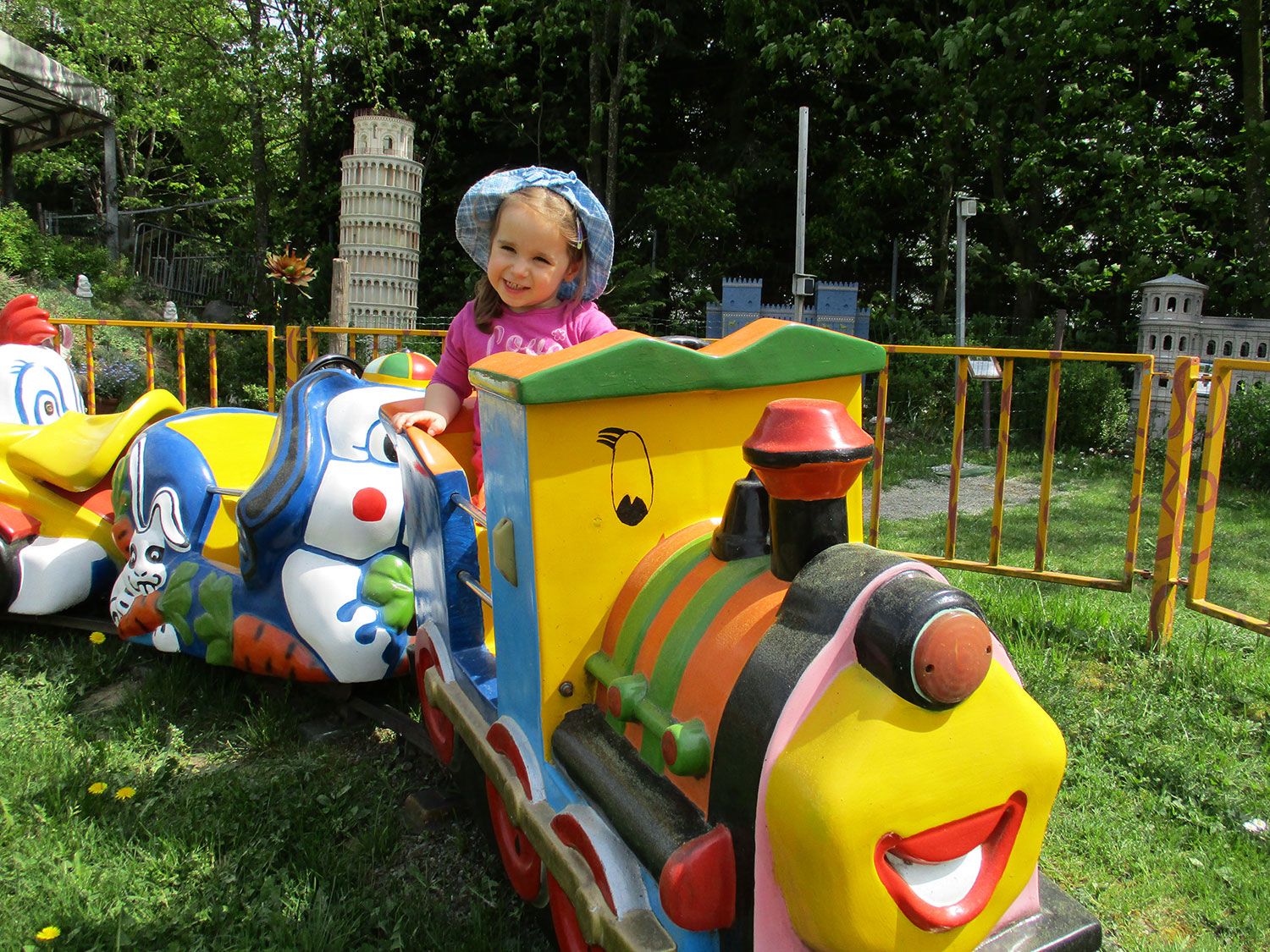 Child on a colorful carousel train in the Hubhof family park.