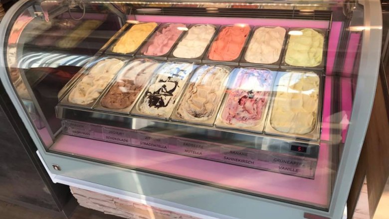 Ice cream display case with different types of ice cream in an ice cream parlor.