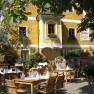 Terrace of an inn with laid tables and plants.