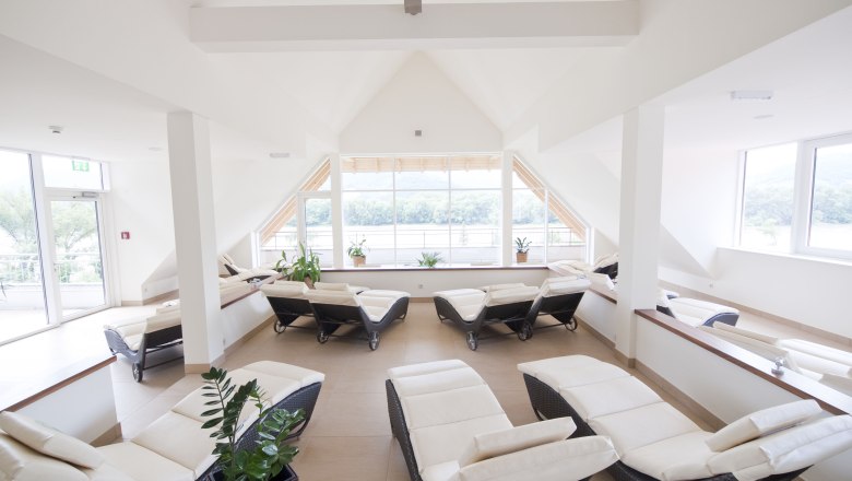 Bright spa room with loungers and large windows.