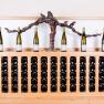 Wine bottles on a wooden shelf with grapevine decoration.