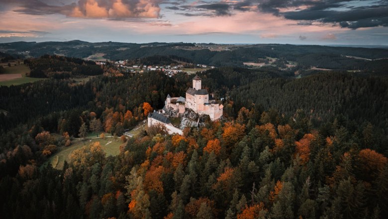 Aerial view of Rappottenstein Castle surrounded by autumnal forests.