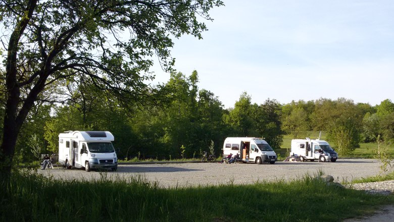 Motorhome parking space at the National Park House, © NP Thayatal Motorhomes on a pitch in the countryside, surrounded by trees.