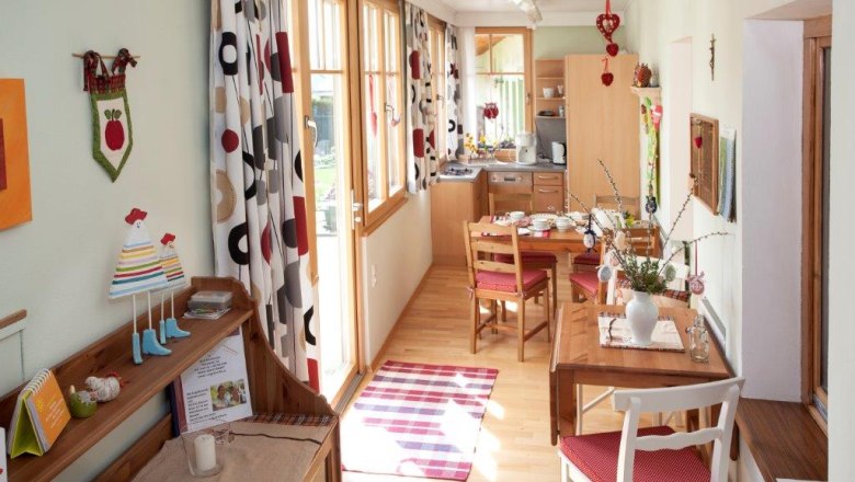 Cozy vacation apartment with wooden furniture, dining table and decorative curtains.