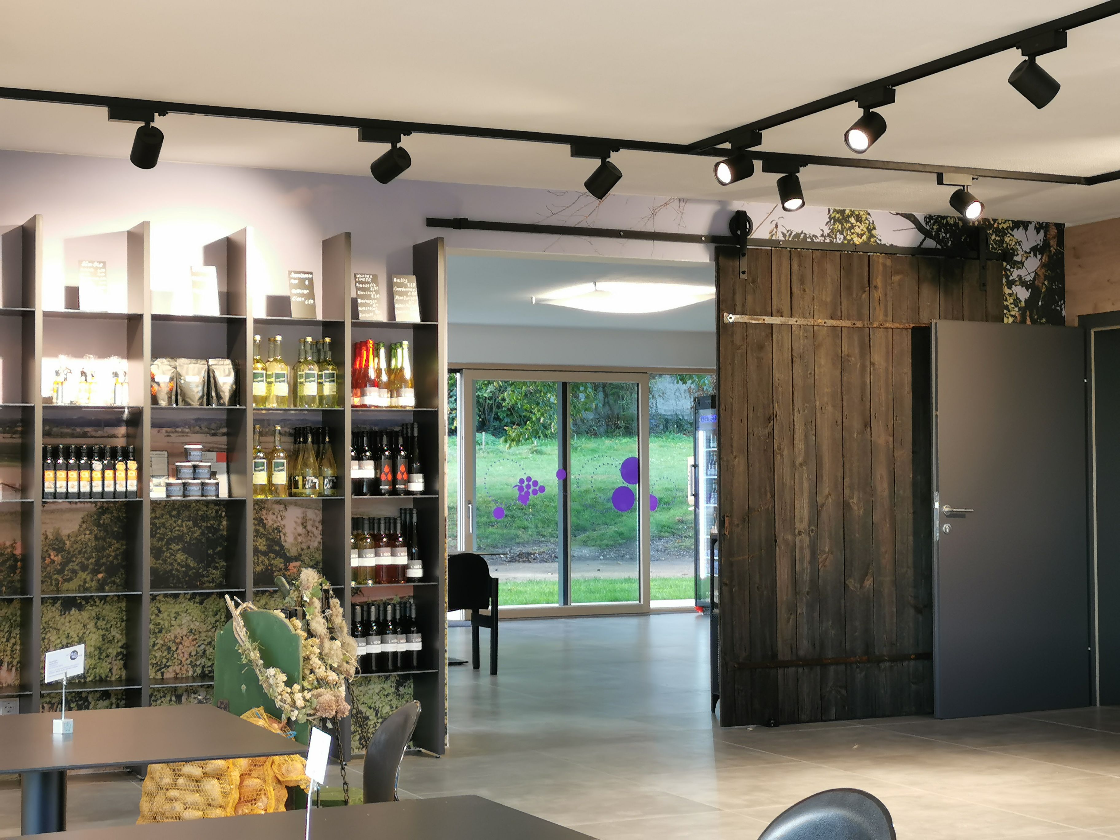 View of the farm store with a shelf of wine and other products.