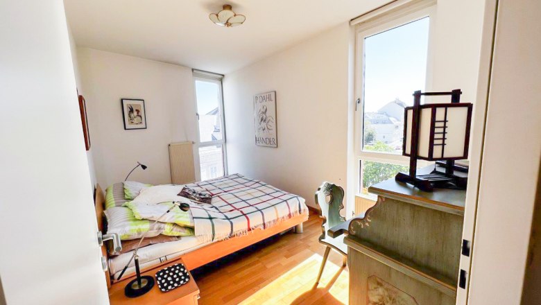 Bright bedroom with bed, desk and window.