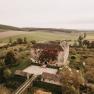 Aerial view of Haggenberg Castle surrounded by fields and trees.