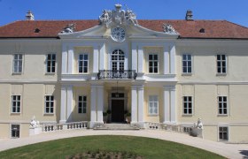 Front view of Liechtenstein Castle with clock and sculptures on the roof.