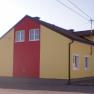 Exterior view of a yellow-red building with several windows and a pitched roof.