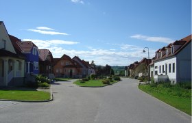 Street in Alberndorf with colorful houses and blue sky.