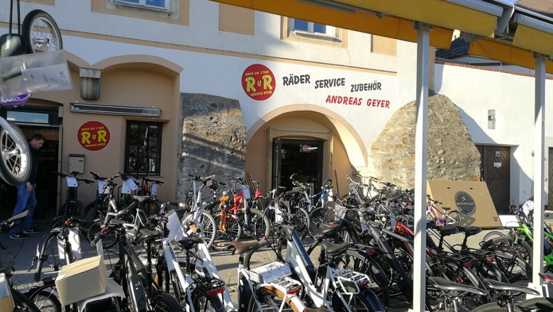 Bicycle store with many bicycles in front of the entrance.