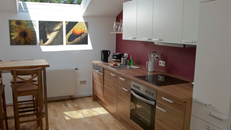 Modern kitchen with wooden worktop, skylight and murals.
