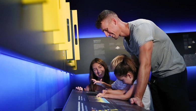A family interacts with an exhibition in a museum.