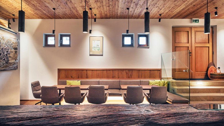 Modern interior with wooden elements, seating area and decorative lamps.