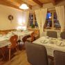 Cozy breakfast room with laid tables, wooden furniture and decorations.