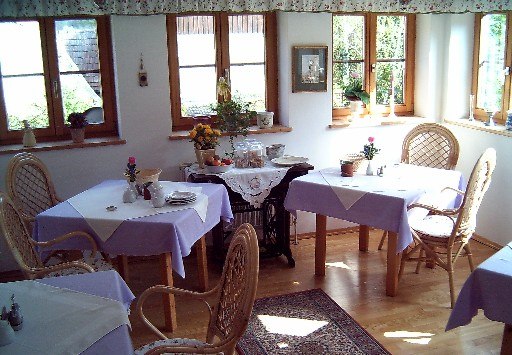Guest room Lengsteiner, © Fam. Lengsteiner Cozy breakfast room with wicker chairs and purple tablecloths.