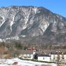 Mountain landscape with buildings in the foreground and snow-covered mountains in the background.