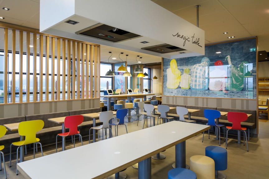 Interior view of a modern McDonald's restaurant with colorful chairs and tables.