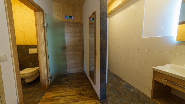 Modern bathroom with wooden elements and glass details.