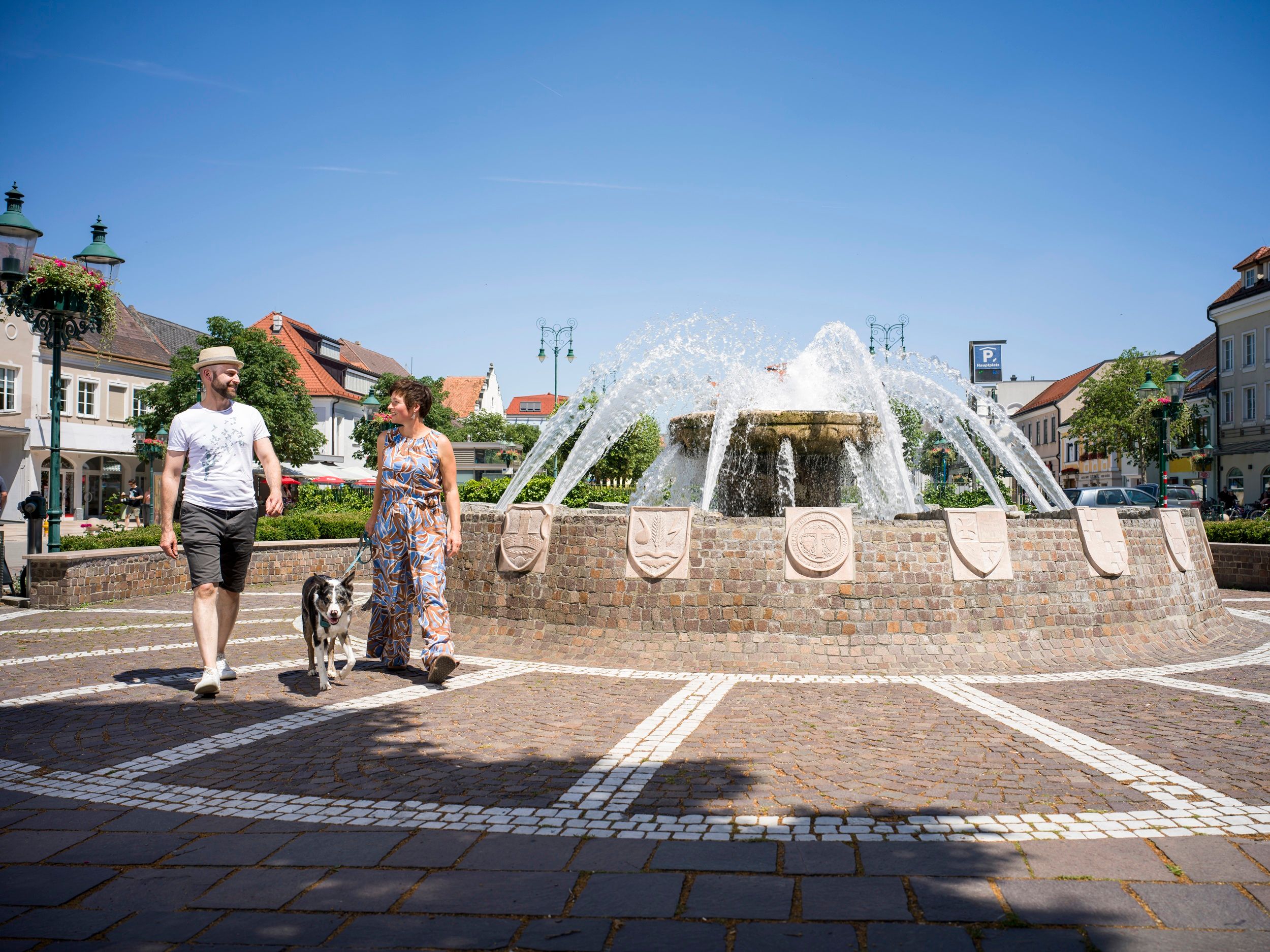 People walking by the Bezirksbrunnen fountain on Tulln's main square