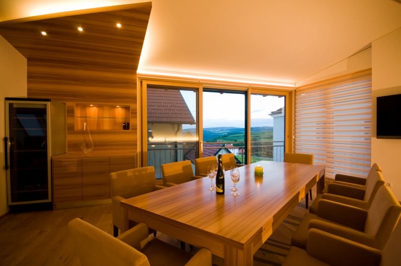 Modern tasting room with wooden table, chairs and panoramic window overlooking the countryside.