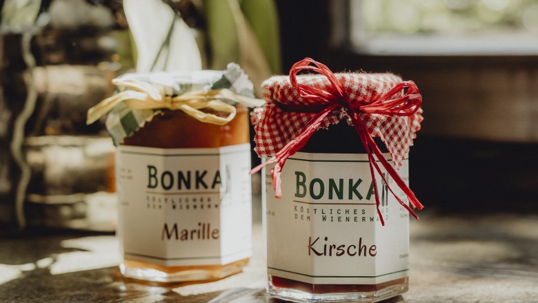 Two jars of jam labeled 'Bonka', one with apricot, the other with cherry, on a table.
