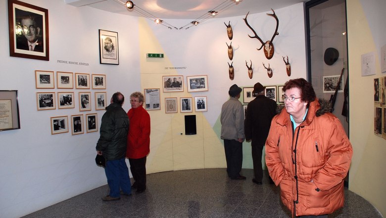 Visitors to the Leopold Figl Museum view photos and hunting trophies on the walls.