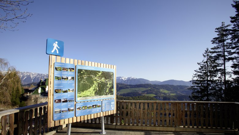 Hiking starting point Semmering with information board and mountain landscape in the background.