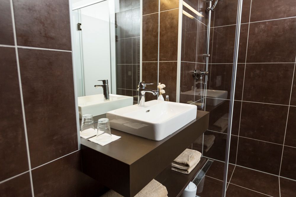 Modern bathroom with washbasin, mirror and shower.