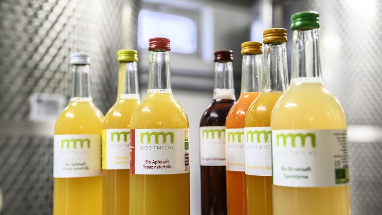 Bottles of various organic juices from MostMichl on a shelf.