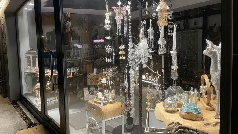Shop window with decorative objects and crystal pendants.