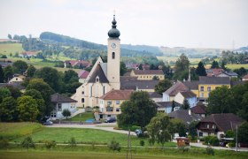 View of the market town of Ruprechtshofen with church and surrounding houses in a rural landscape.