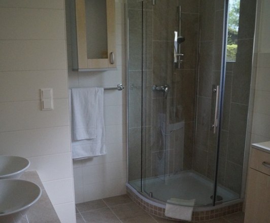Modern bathroom with shower, washbasin and towel rail.