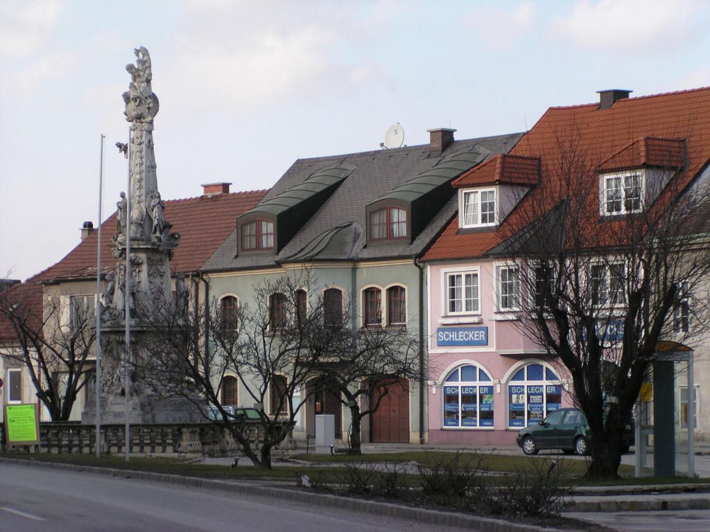 Street scene in Ebenfurth with historic buildings and a statue.