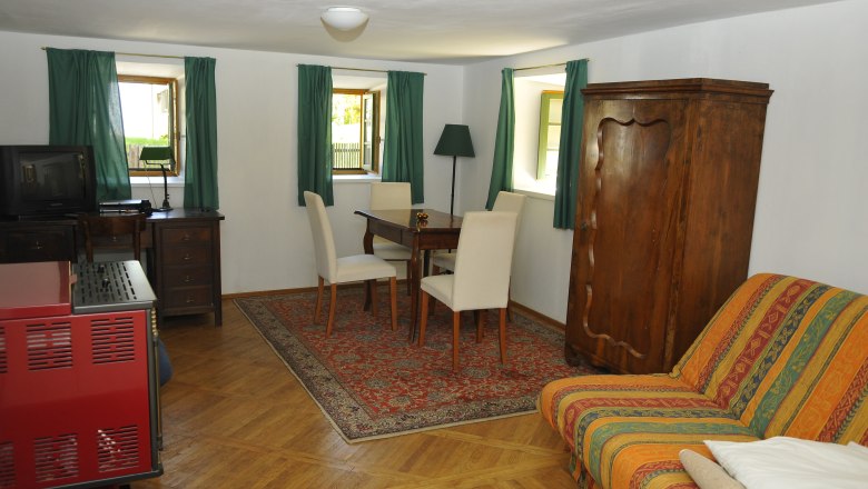 Cozy guest room with wooden furniture, carpet and sofa.