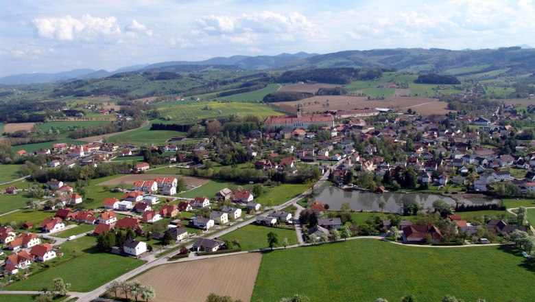 Aerial view of Seitenstetten with fields, houses and hills in the background.