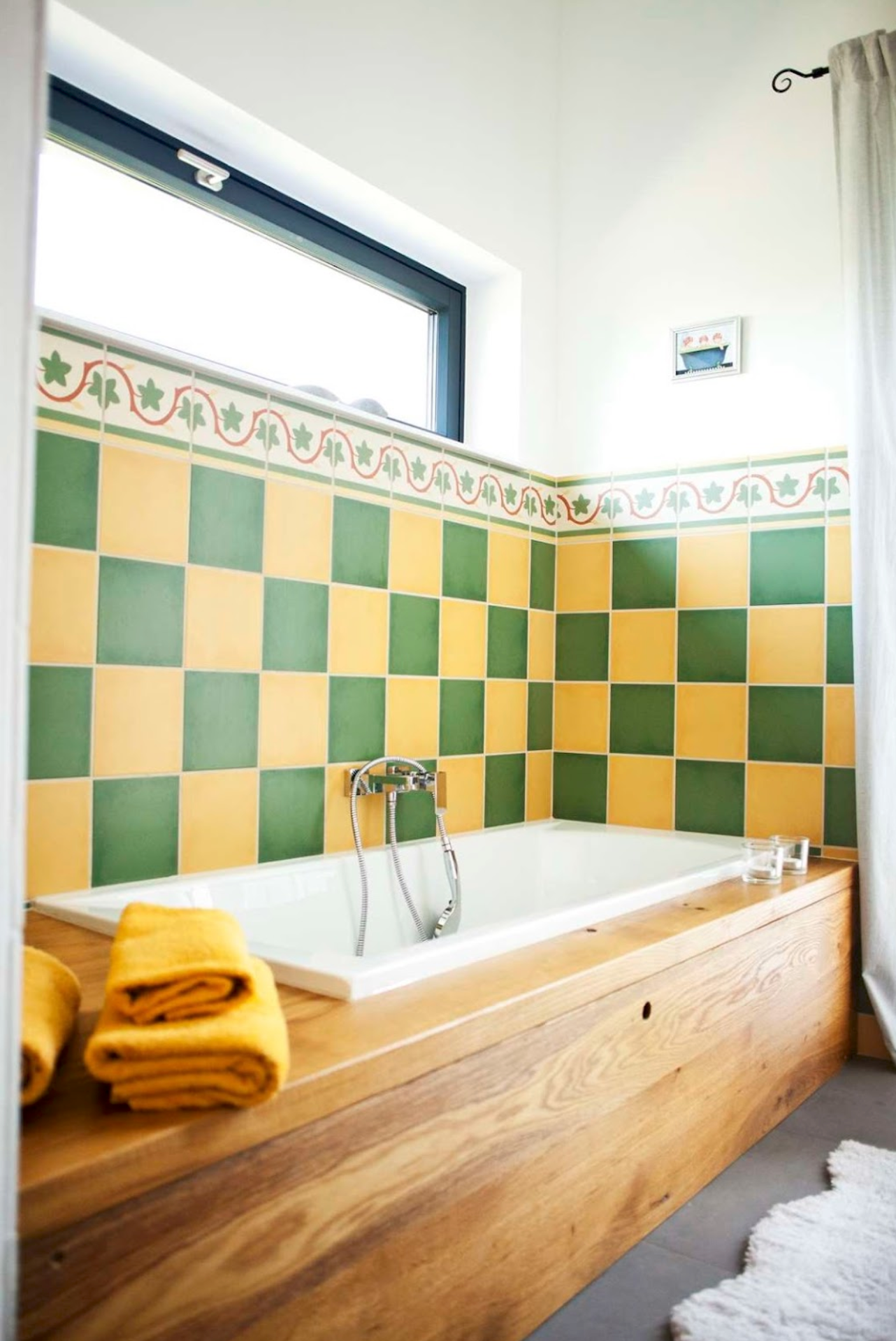 Bathroom with bathtub, yellow-green tiles and wood paneling.