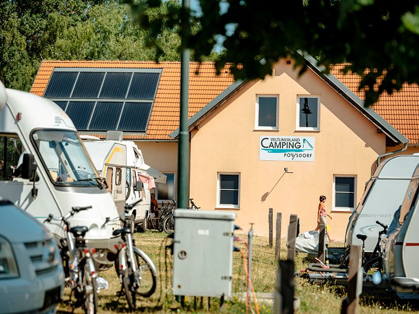 Campsite with mobile homes and sanitary building in the background.