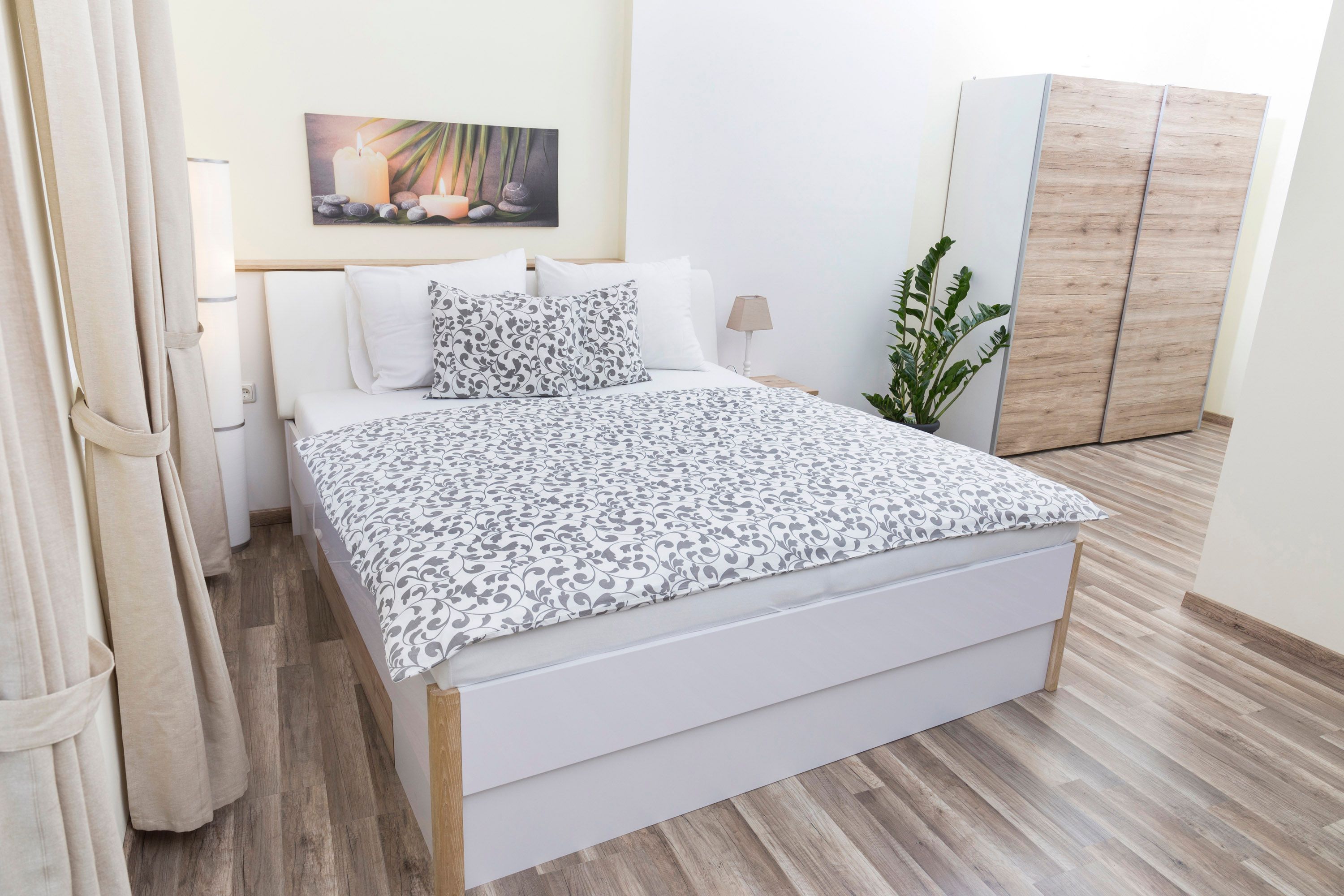 Modern bedroom with double bed, plants and wardrobe.