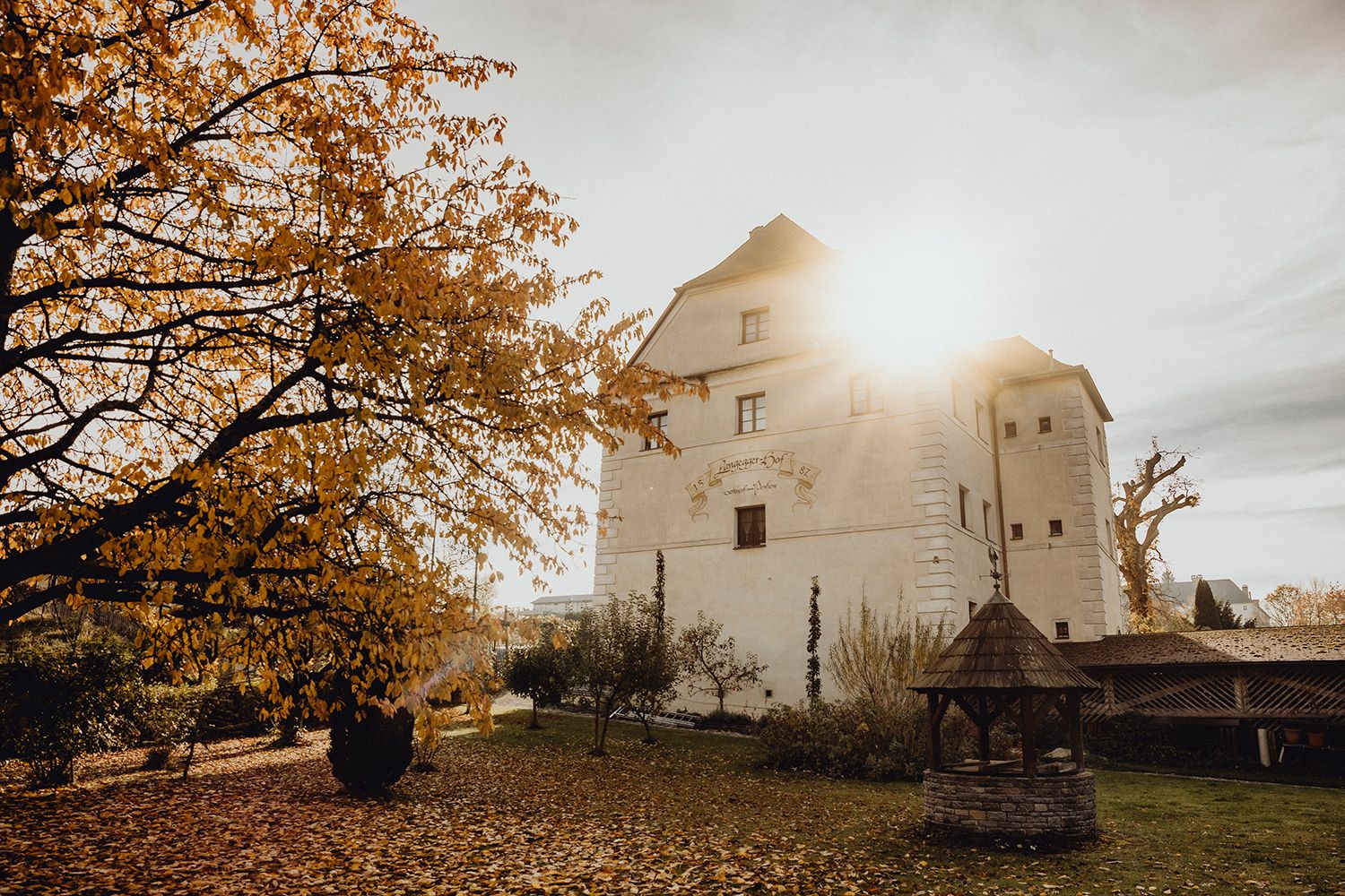 Autumn scene with historic building and tree in the sunlight.