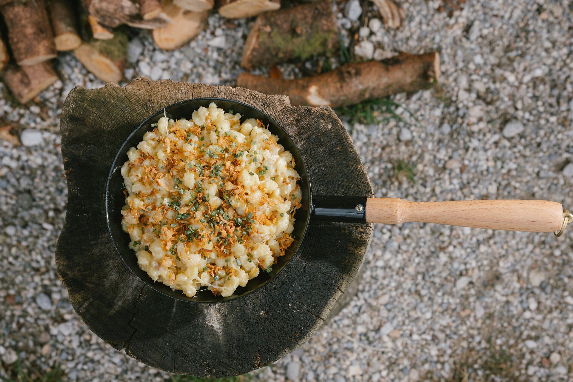 Cheese spaetzle in a pan with caramelized onions and herbs