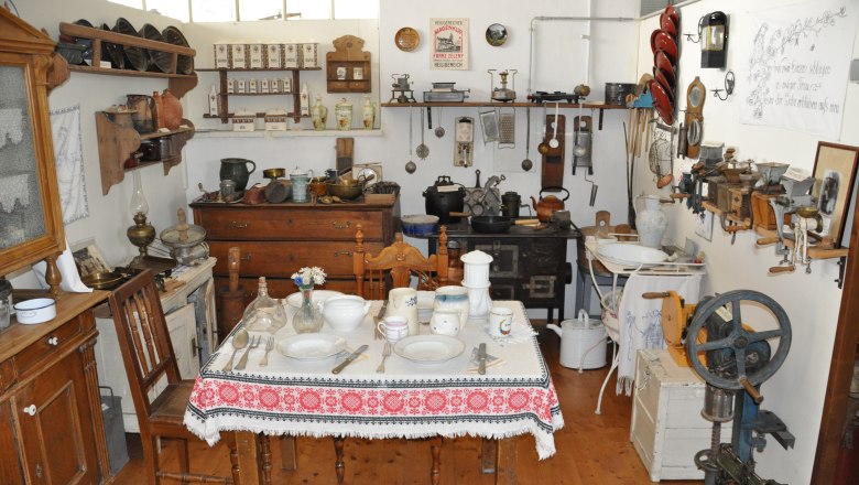 A room in the Michelhausen local history museum with antique kitchen utensils and furniture.