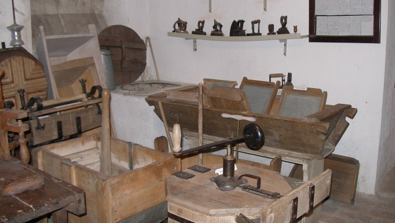A room with old household appliances such as washboards and irons.