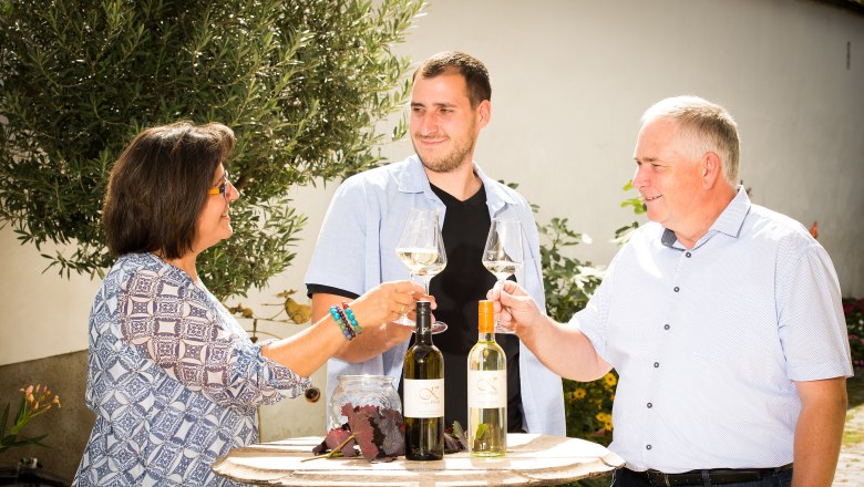 The Krell family toast each other with a glass of wine in the courtyard.