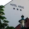 Facade of the Hotel Krug with three stars, tree and street lamp.